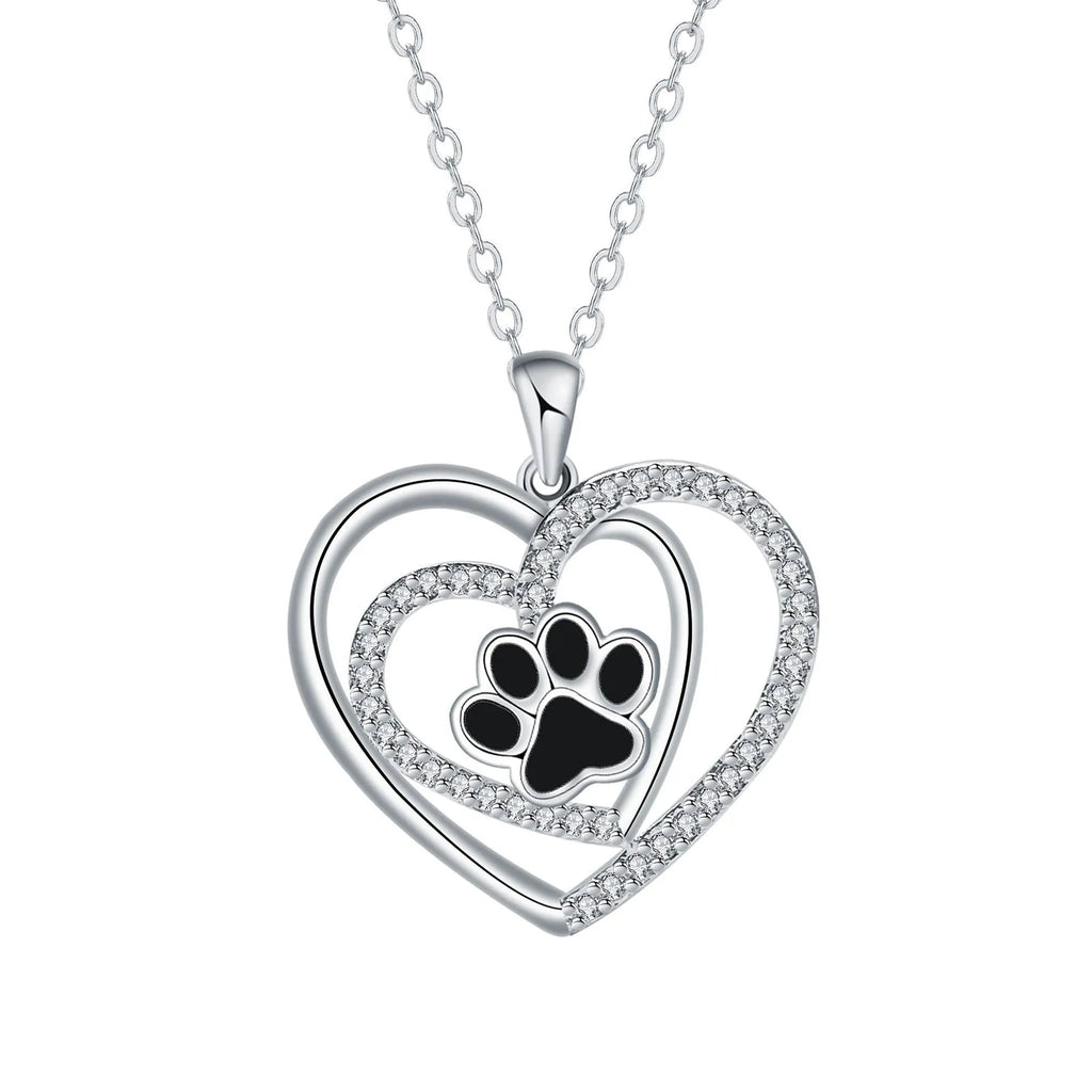 Gold tone dog paw print and heart charm necklace on a cross chain for women.