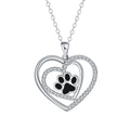 Gold tone dog paw print and heart charm necklace on a cross chain for women.