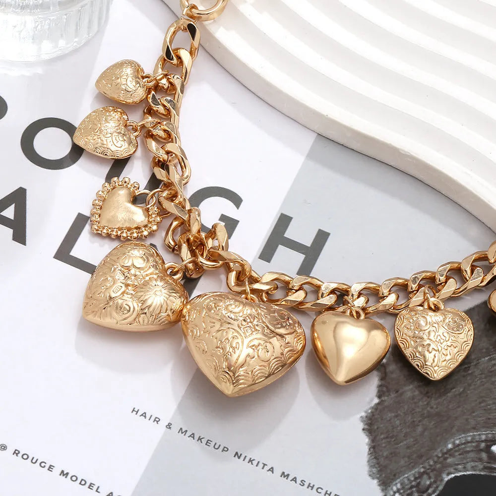 Exaggerated carved heart-shaped pendant necklace on an adjustable metal chain, shown in a gold colour finish.