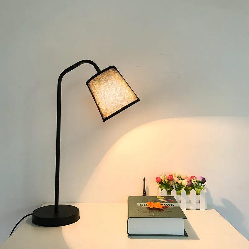 A modern LED table lamp with a push button dimmer switch on its base.