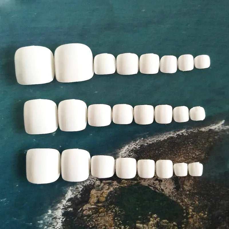 Set of white press-on artificial nails with a starry sky pattern.
