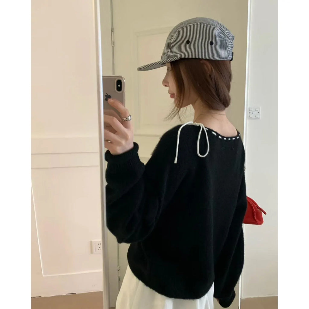 A grey loose-fitting women's knitwear pullover, shown on a hanger.