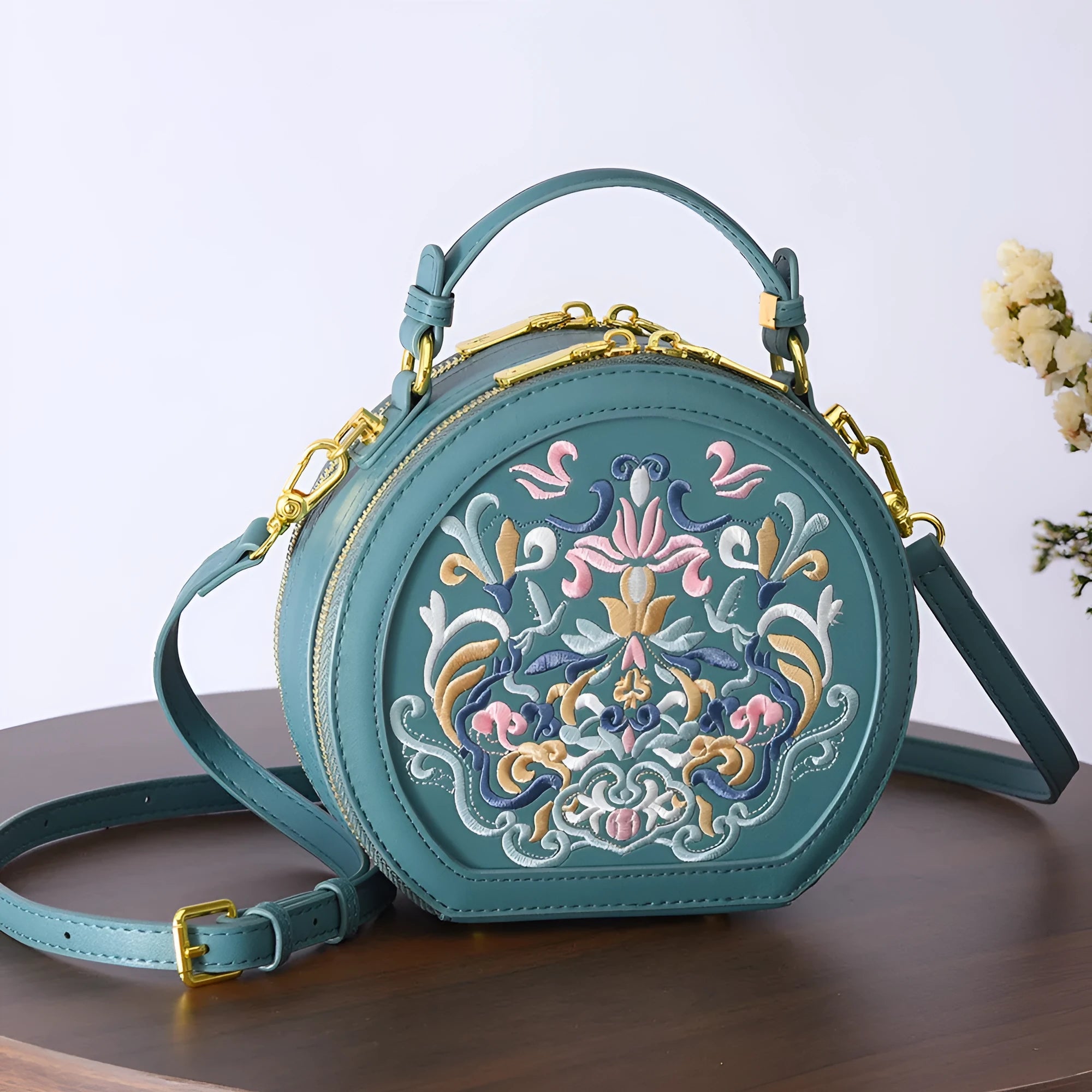 National style round crossbody bag in khaki PU leather with embroidery and sewing line details, shown on a plain background