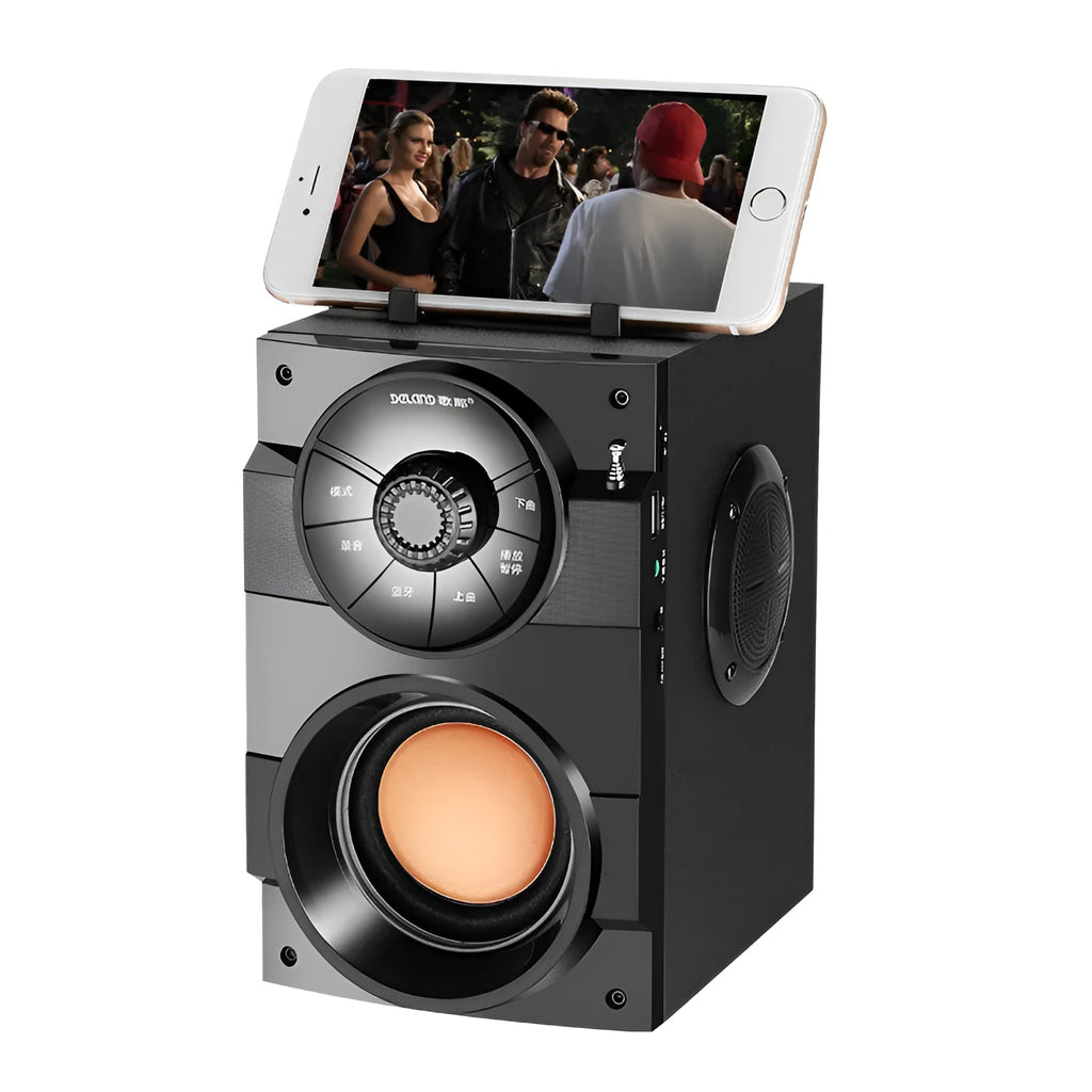 Black portable mini home audio system with subwoofer, satellite speakers, and USB charging cable on a desk.
