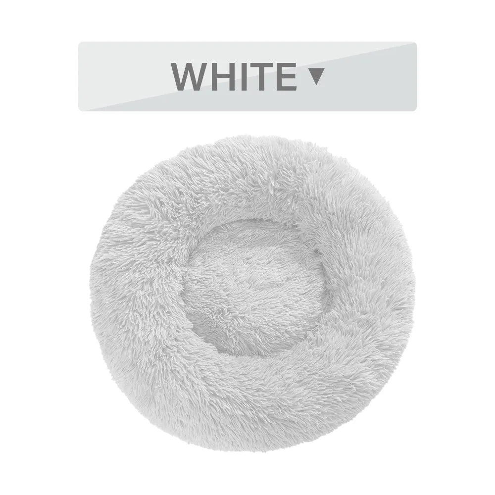 Fluffy donut-shaped dog bed in light grey plush material, showing raised rim and central cushion.