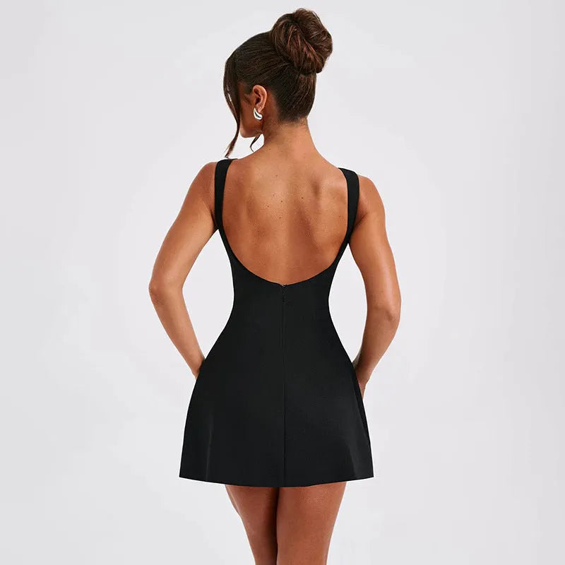 Black backless sling dress with slim fit and short skirt on a model.