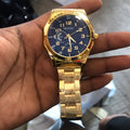 Gold-tone analog watch with round dial and metal link bracelet on a white background