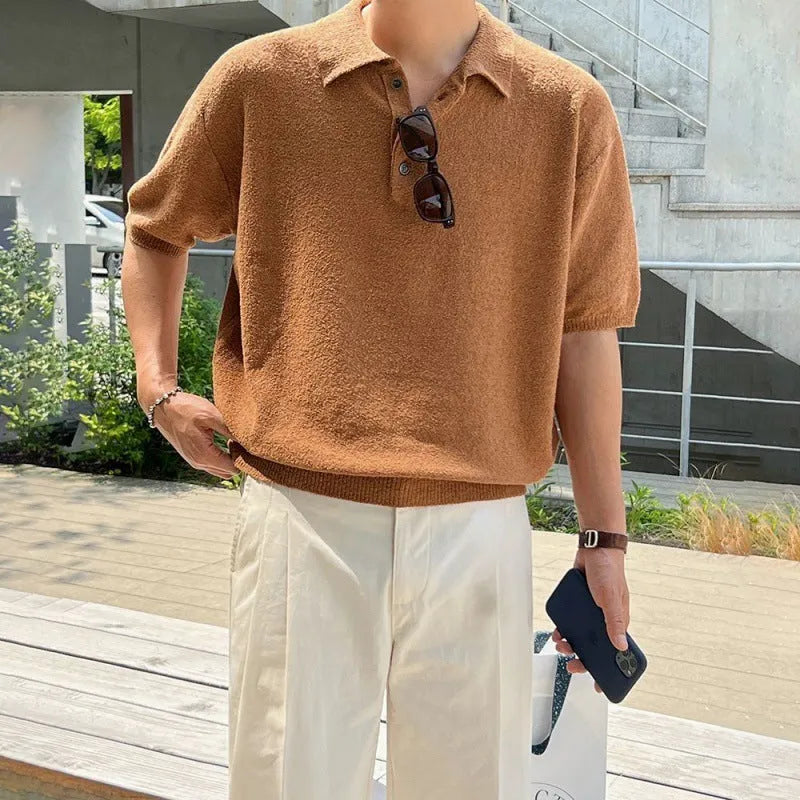 Man wearing a caramel coloured loose fit knitted polo shirt with short sleeves and an asymmetric design.