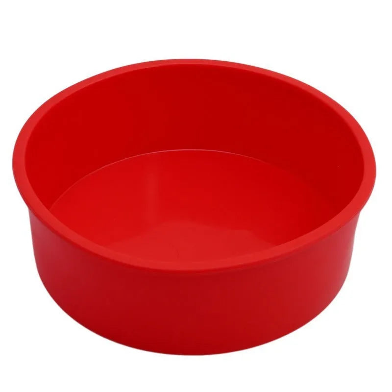 Set of three round red silicone cake moulds in 4-inch, 6-inch, and 8-inch sizes on a baking tray.
