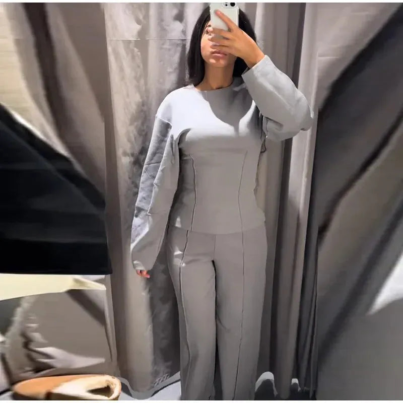 Women's black polyester pleated top and wide leg trousers suit set on a hanger