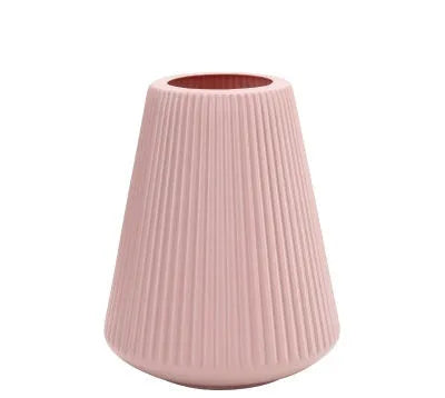 A simple white melamine plastic decorative flower vase on a wooden tabletop.