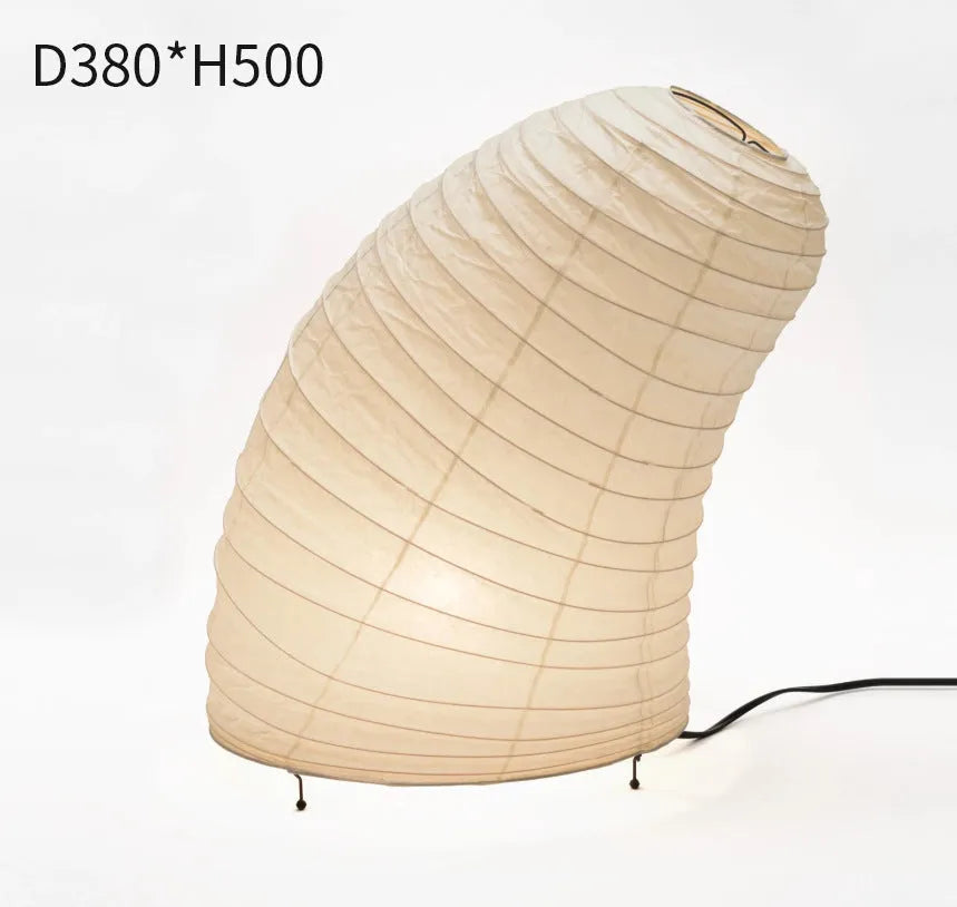 Japanese style table lamp with handmade paper shade and aluminium base on a wooden surface.
