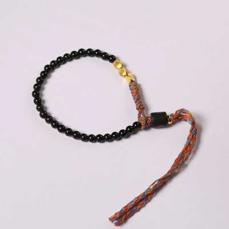 Slender dark obsidian hand-woven bracelet strap shown on a wrist