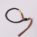 Slender dark obsidian hand-woven bracelet strap shown on a wrist