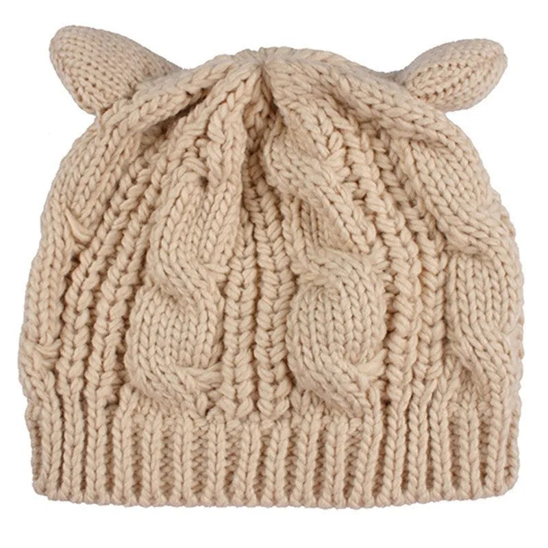 Hand-made red knitted beanie with 3D cat ears on a white background, showing side view.
