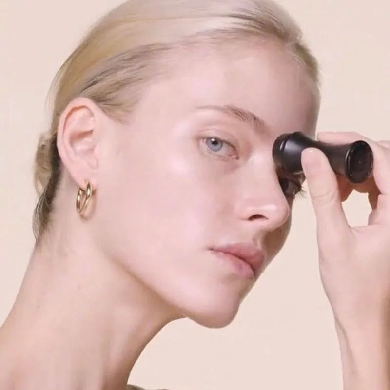 Volcanic stone oil-absorbing facial roller in pink on a white background