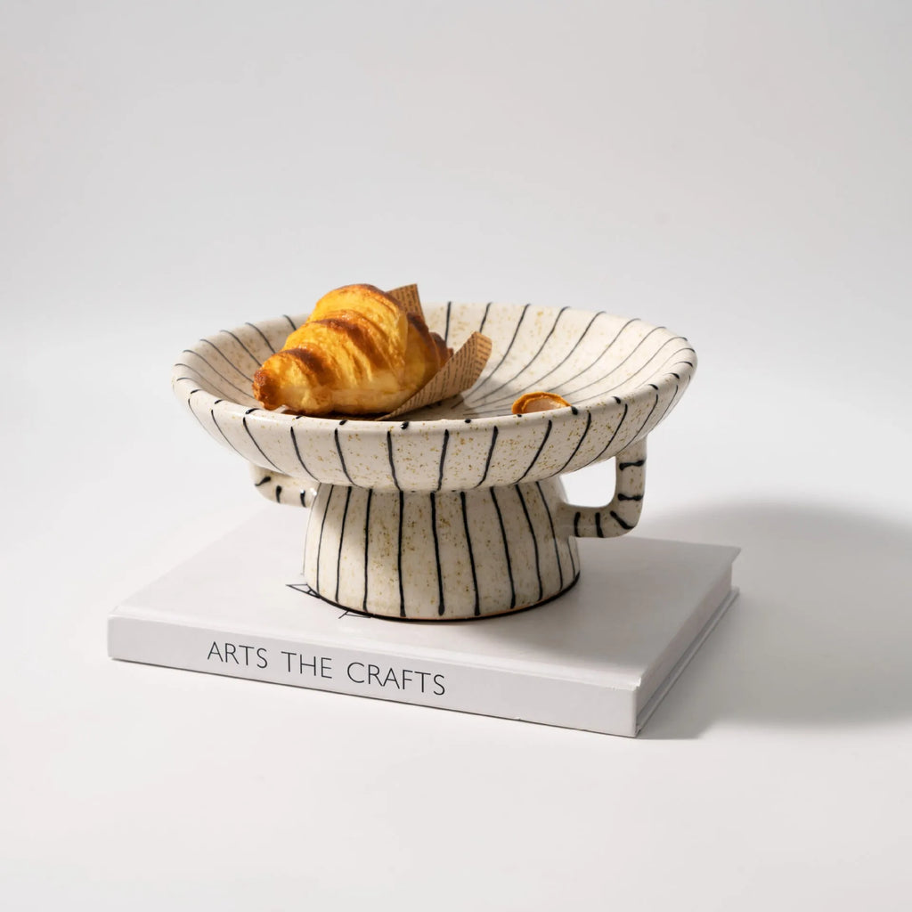 Black and white striped plastic resin fruit plate ornament, 16cm diameter, on a table.
