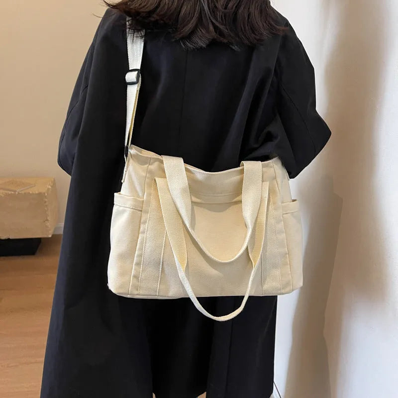 Women's large capacity canvas shoulder bag in solid colour with outer pocket and internal phone compartment