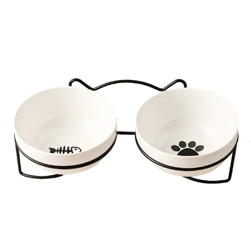 White ceramic cat bowl with paw print design in a black iron cat-ear frame.