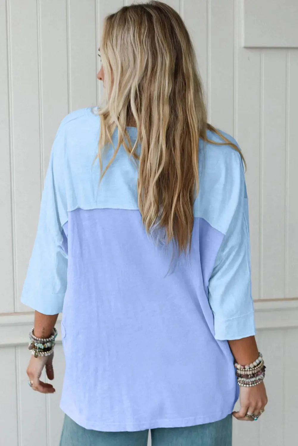 Light blue T shirt with flower patch, exposed seam bracelet sleeves, and oversized fit in sizes S M L XL
