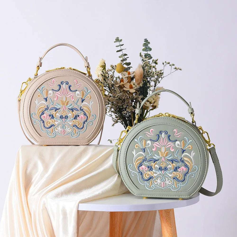National style round crossbody bag in khaki PU leather with embroidery and sewing line details, shown on a plain background