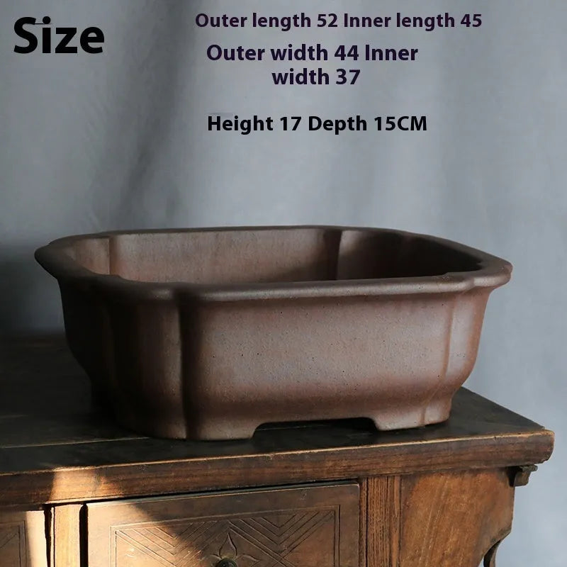 Purple sand rectangular ceramic bonsai pot on a flat surface.