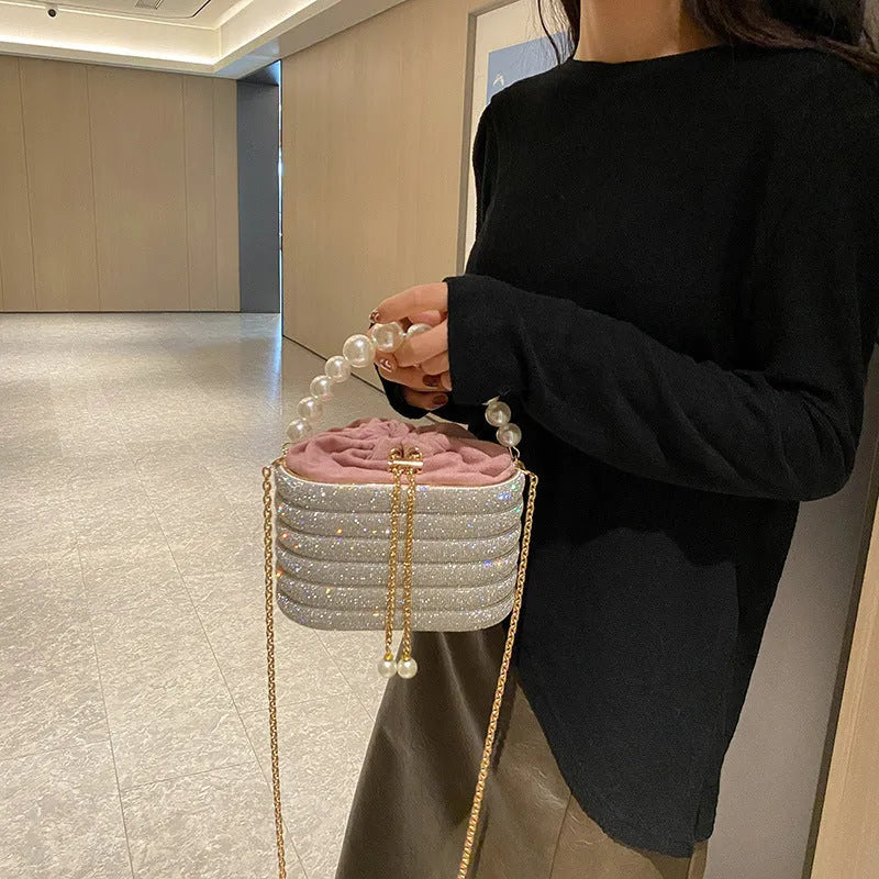 Women's black one-shoulder crossbody bag with pearl beading on the front.