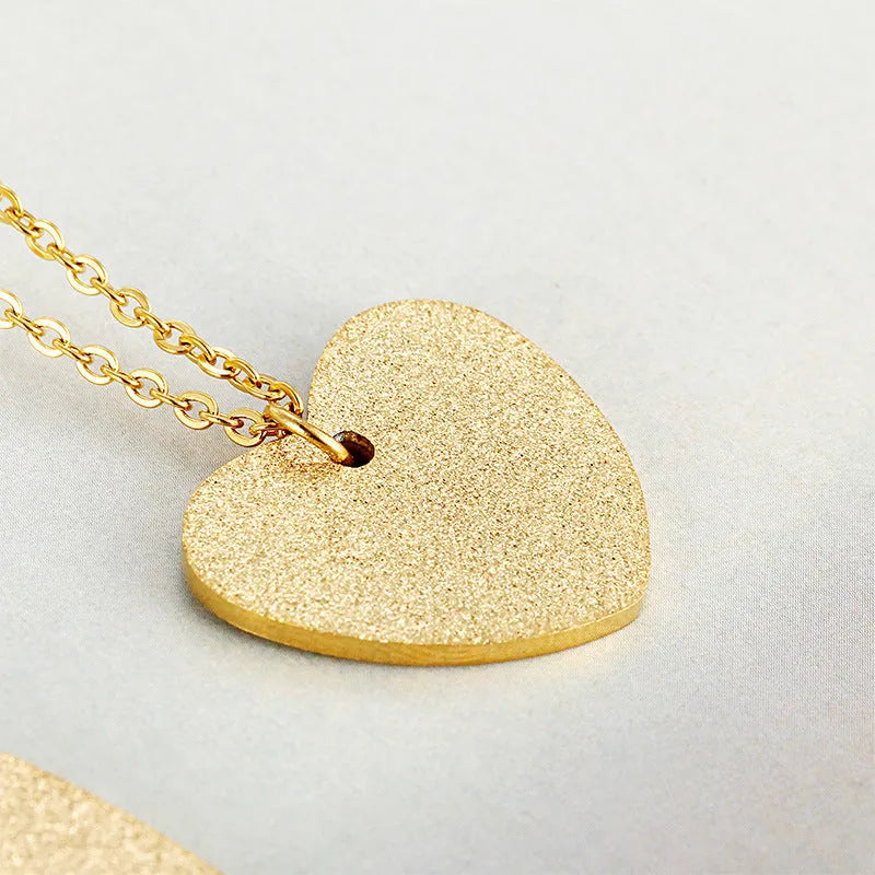 Close-up of a women's geometric heart-shaped titanium steel pendant necklace on a chain.