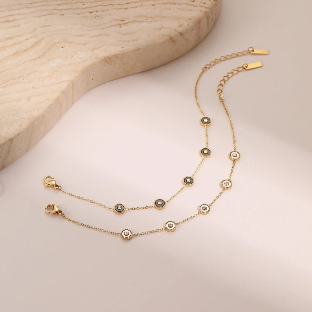 Geometric fritillary design bracelet and necklace set with 18K gold plating on stainless steel.