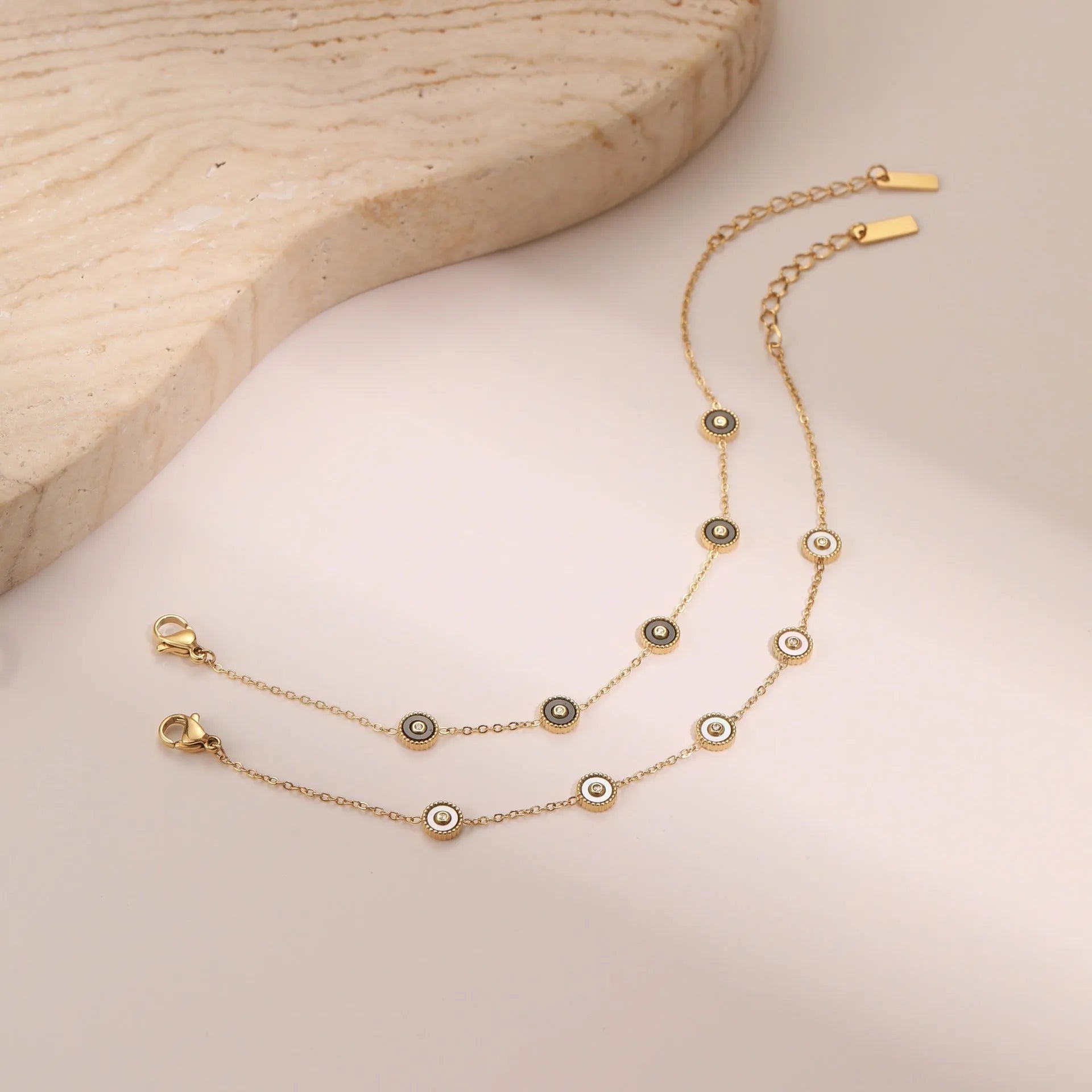 Geometric fritillary design bracelet and necklace set with 18K gold plating on stainless steel.