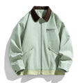 Man wearing a mint green retro-style jacket with dark contrast lapels and side pockets.