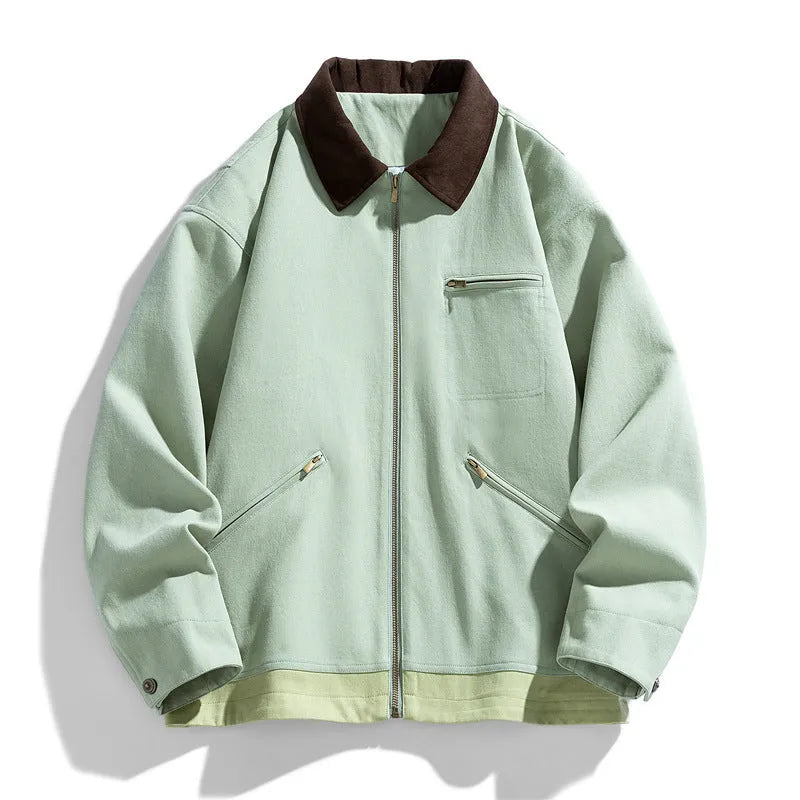 Man wearing a mint green retro-style jacket with dark contrast lapels and side pockets.