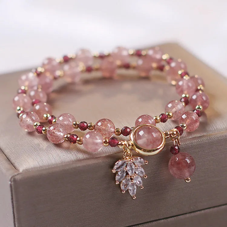 Women's double layer Strawberry Quartz crystal bracelet with Lucky Cat charm and red cat's eye flowers.