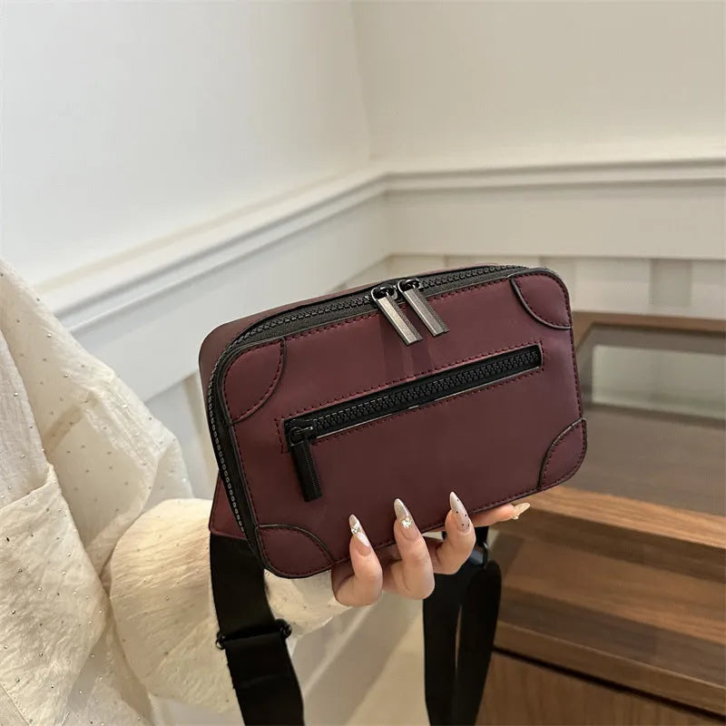A dark grey women's square crossbody bag made of PU leather, shown with a single shoulder strap and visible sewing line detail.