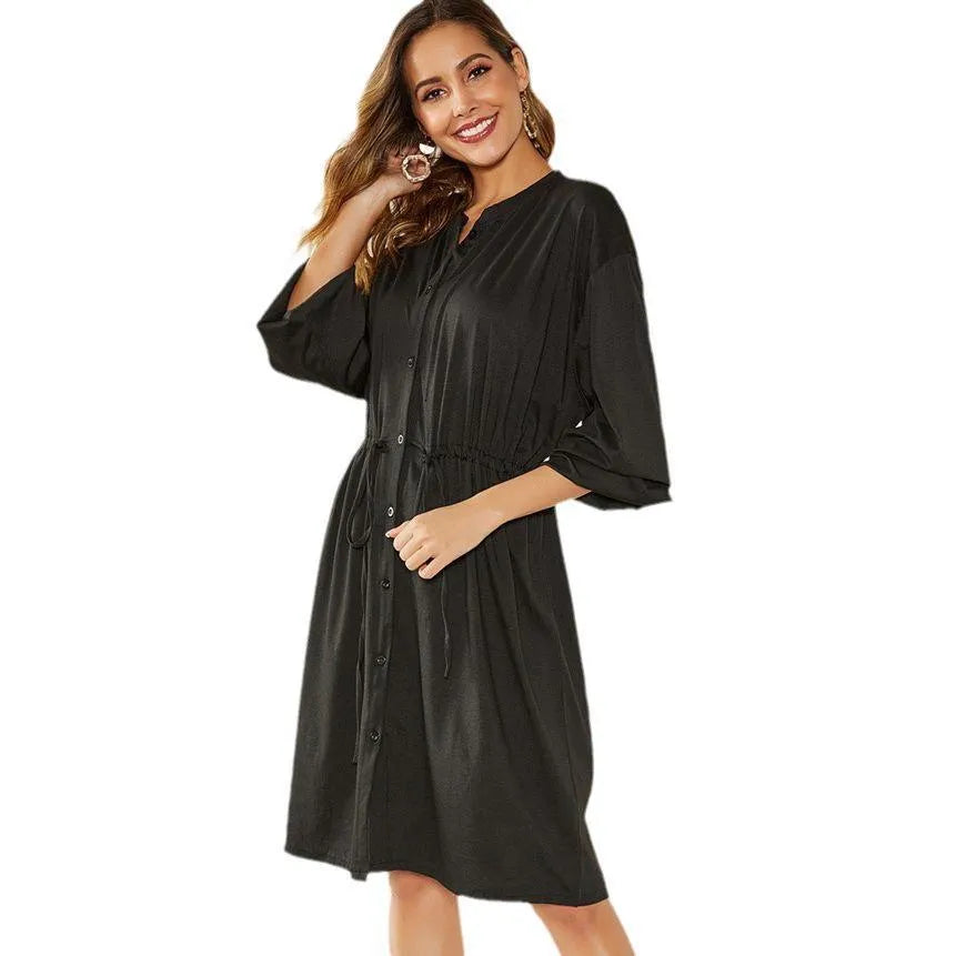Black A-line midi dress with elastic waistband and cinched belt, long sleeves with elastic cuffs