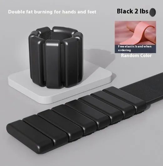 A black silicone wrist weight bracelet with Velcro fastener shown on a wrist.