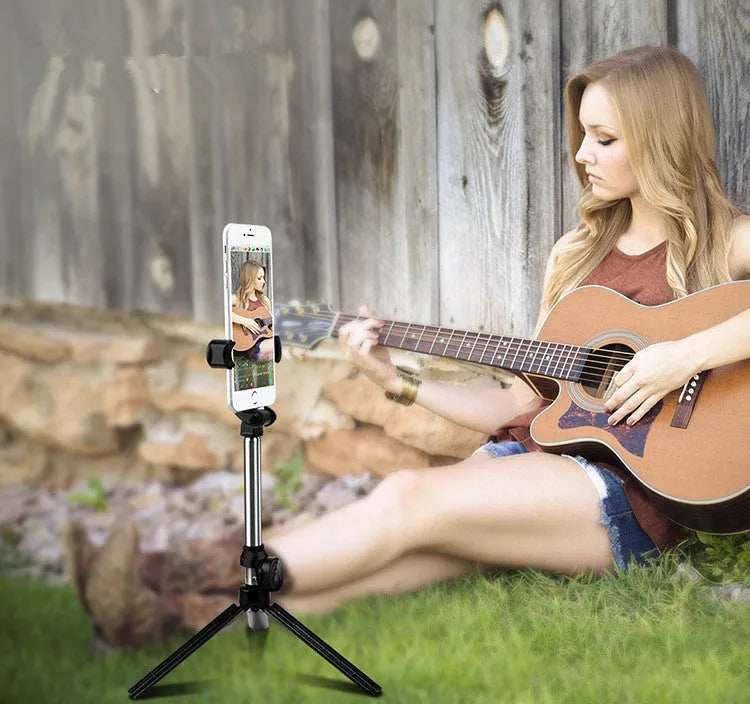 Bluetooth selfie stick tripod with aluminium pole extended, showing phone clip rotation and foldable legs