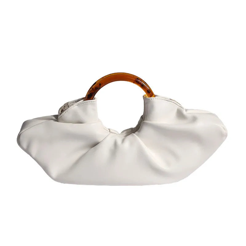 Niche horn bag in black or white PU leather with acrylic ring handle and fold detail for daily matching.
