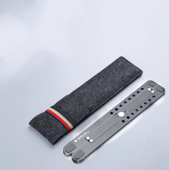 Portable aluminium laptop stand folded flat next to an open laptop showing its adjustable height.