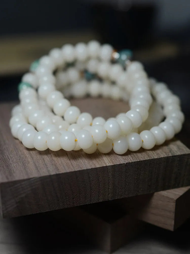 White Jade Bodhi Root Oblate Bead Bracelet with 108 flat round beads on a wrist.