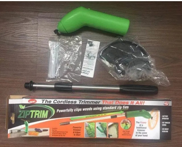 Cordless handheld grass trimmer with extension pole and protective shield on a garden lawn