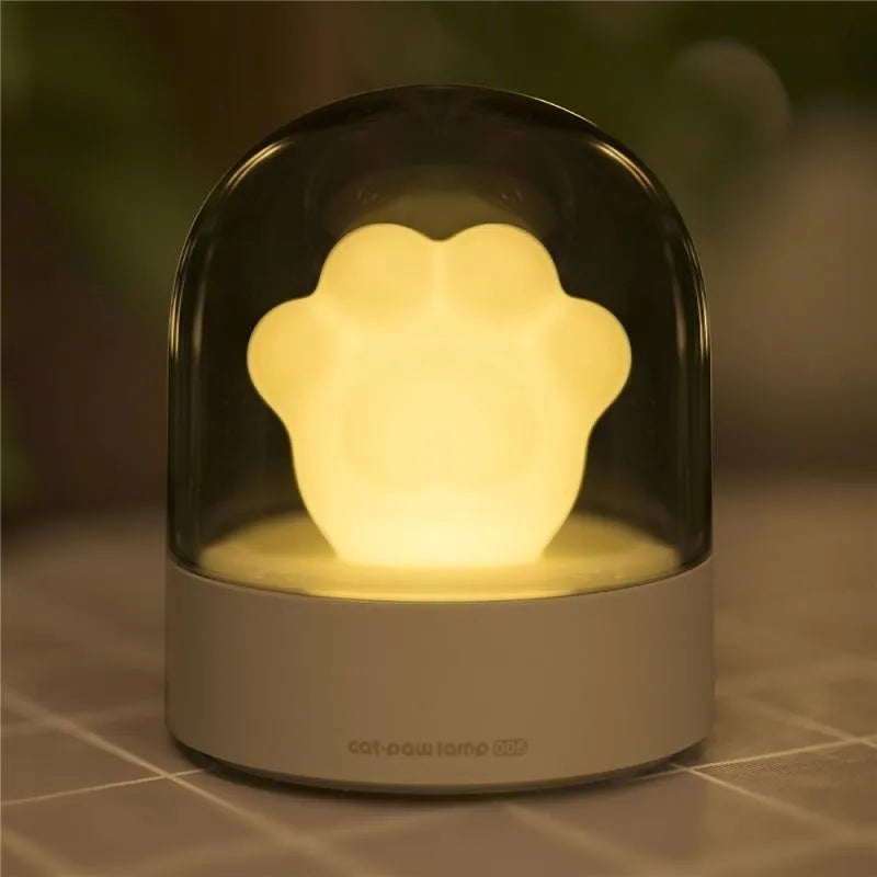 Grey cat paw shaped USB rechargeable night light with music box function on wooden desktop