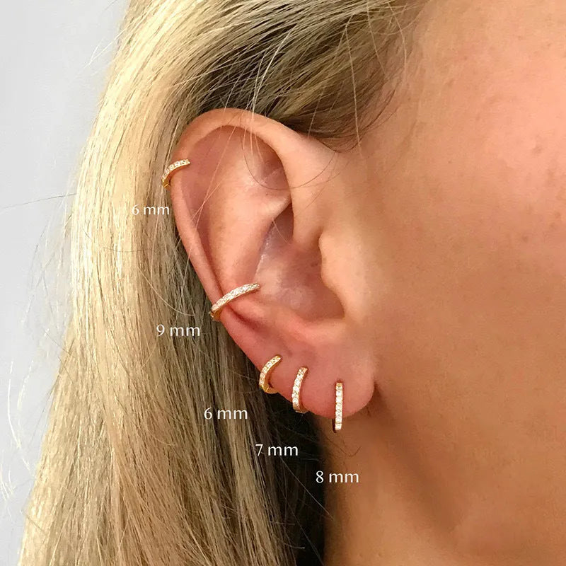 A pair of round geometric stud earrings with a perforated design in a gold electroplated finish.