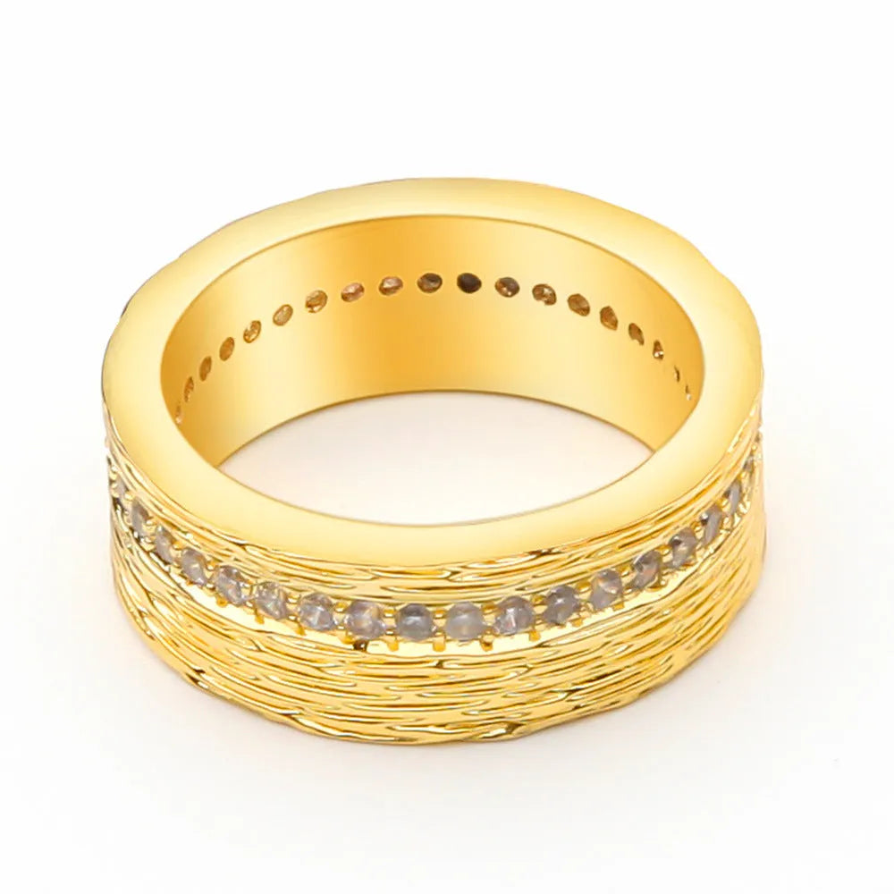 Geometric gold-coloured zircon ring for women on a plain background.