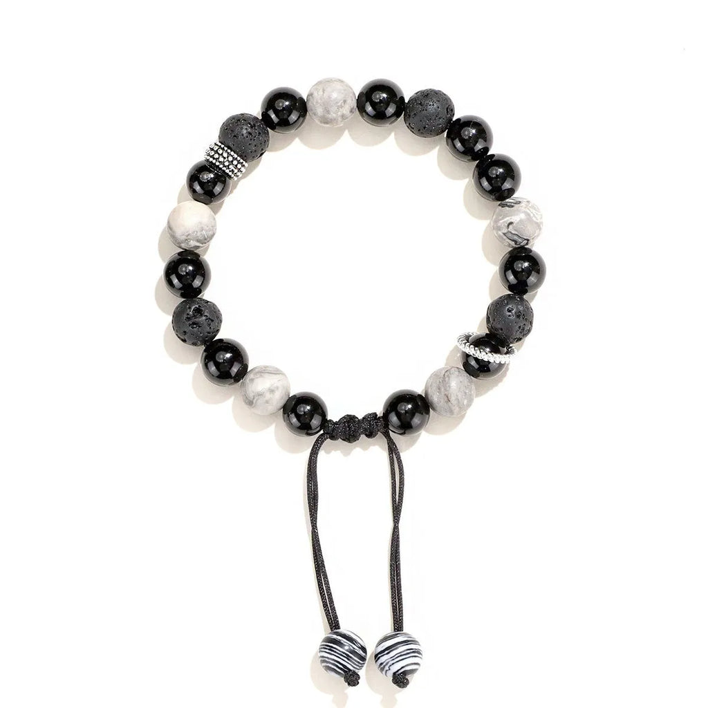 Black agate map stone volcanic rock bracelet with diamond-shaped cuts on wrist.