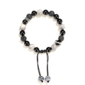 Black agate map stone volcanic rock bracelet with diamond-shaped cuts on wrist.