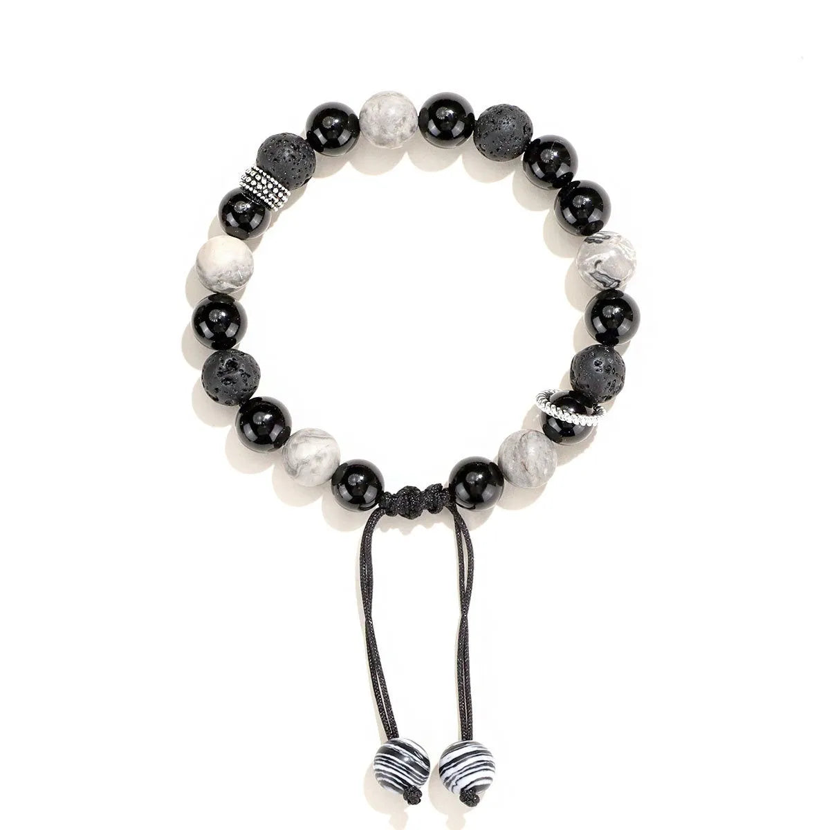 Black agate map stone volcanic rock bracelet with diamond-shaped cuts on wrist.