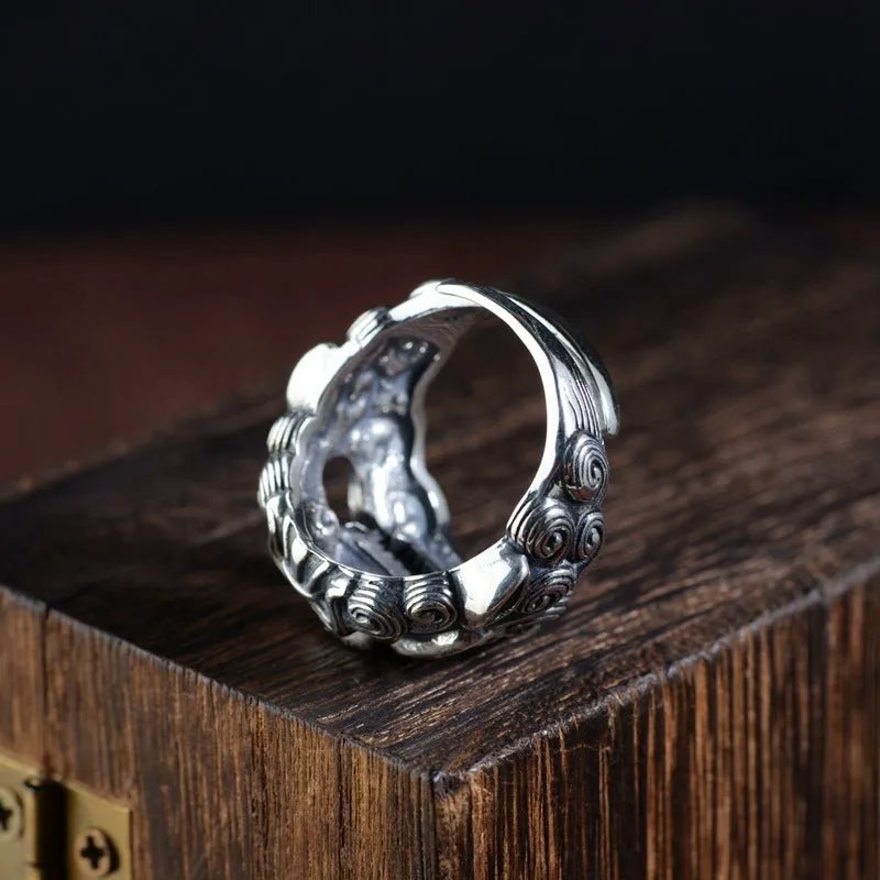 Silver open ring with detailed Jibeast and zodiac animal pattern, shown on a hand.
