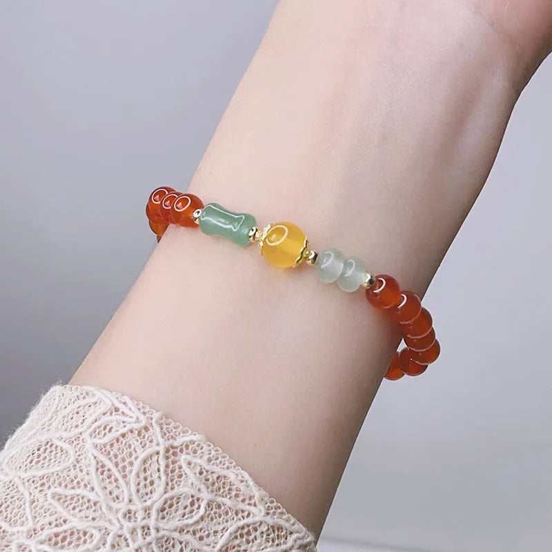 Close-up of a red agate bracelet with a Chinese dragon design on a woman's wrist.