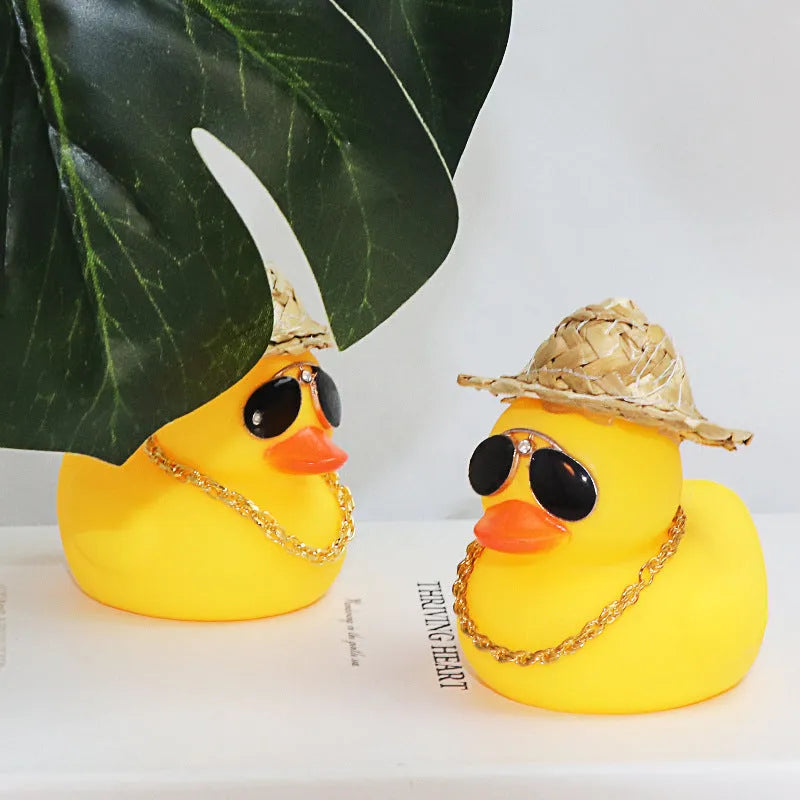 Yellow cartoon duck with straw hat car ornament on dashboard with sunglasses accessory